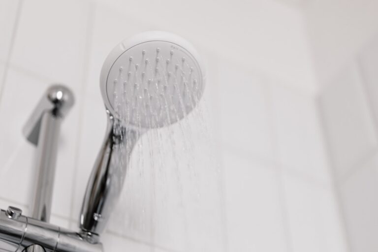 Close-up of a shower head releasing water droplets.