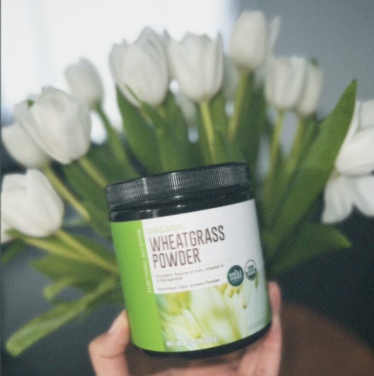 Close-up of fresh wheatgrass on a white wooden box, representing the natural and vibrant green color of wheatgrass, a superfood known for its health benefits for women.